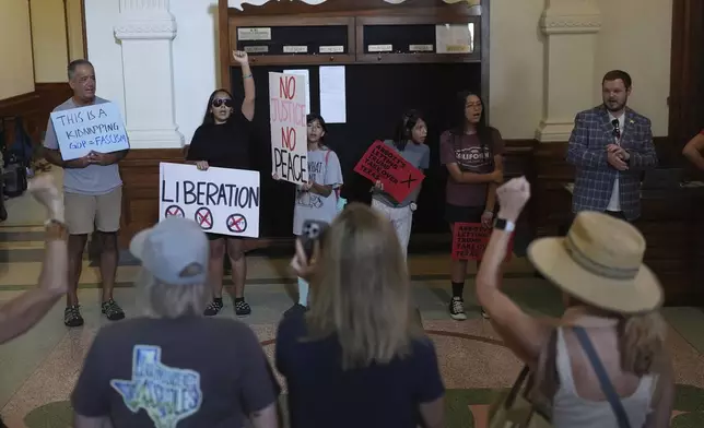 Protesters gather outside of the House Chamber where Democratic Texas Rep. Nicole Collier refuses to leave due to a required law enforcement escort, Tuesday, Aug. 19, 2025, in Austin, Texas. (AP Photo/Eric Gay)