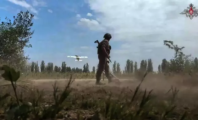 In this photo taken from video distributed by Russian Defense Ministry Press Service on Monday, Aug. 18, 2025, A Russian soldier launches a drone in an undisclosed location in Ukraine. (Russian Defense Ministry Press Service via AP)