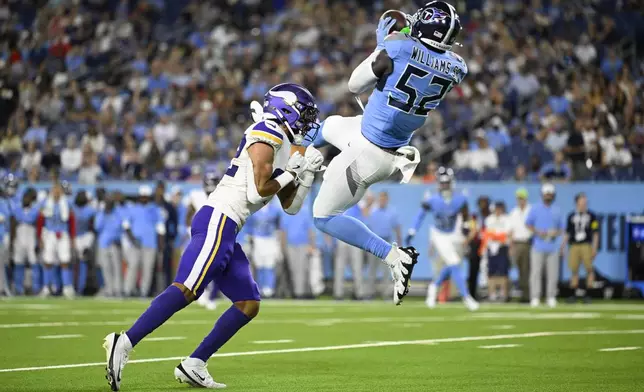 Tennessee Titans linebacker James Williams Sr. (52) intercepts a pass over Minnesota Vikings wide receiver Jeshaun Jones (82) during the first half of a preseason NFL football game, Friday, Aug. 22, 2025, in Nashville, Tenn. (AP Photo/John Amis)