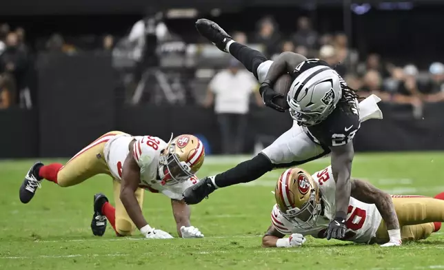 Las Vegas Raiders running back Sincere McCormick (28) leaps over San Francisco 49ers cornerback Chase Lucas (26) of a preseason NFL football game Saturday, Aug. 16, 2025, in Las Vegas. (AP Photo/David Becker)
