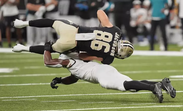 New Orleans Saints tight end Michael Jacobson (86) is upended by Jacksonville Jaguars linebacker Ventrell Miller after a reception in the second half of an NFL preseason football game in New Orleans, Sunday, Aug. 17, 2025. (AP Photo/Gerald Herbert)