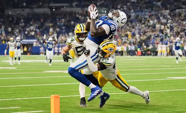 Indianapolis Colts tight end Jelani Woods (80) tries to make a catch while being hit by Green Bay Packers cornerback Tyron Herring (46) during the second half of a preseason NFL football game, Saturday, Aug. 16, 2025, in Indianapolis. (AP Photo/AJ Mast)