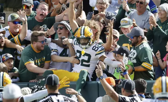 Green Bay Packers' Will Sheppard celebrates his touchdown reception in the stands with fans during the first half of a preseason NFL football game against the Seattle Seahawks Saturday, Aug. 23, 2025, in Green Bay, Wis. (AP Photo/Mike Roemer)