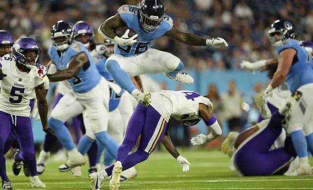 Tennessee Titans running back Julius Chestnut (36) leaps over Minnesota Vikings safety Jay Ward (24) during the first half of a preseason NFL football game, Friday, Aug. 22, 2025, in Nashville, Tenn. (AP Photo/George Walker IV)