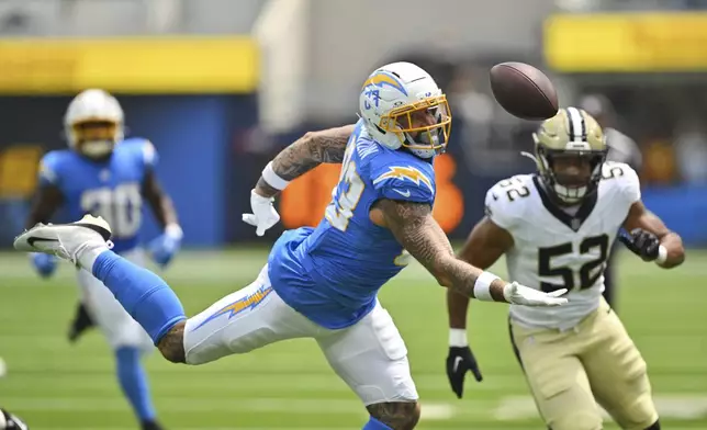 Los Angeles Chargers tight end Tyler Conklin (83) reaches but cannot make a catch in front of New Orleans Saints linebacker D'Marco Jackson (52) during the first half of a preseason NFL football game Sunday, Aug. 10, 2025, in Inglewood, Calif. (AP Photo/Jayne Kamin- Oncea)