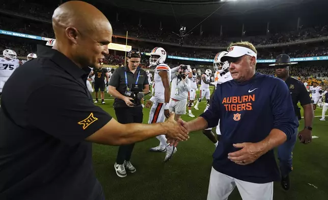 Baylor head coach Dave Aranda, left, shakes hands with Auburn head coach Hugh Freeze following an NCAA college football game Friday, Aug. 29, 2025, in Waco, Texas. (AP Photo/Julio Cortez)
