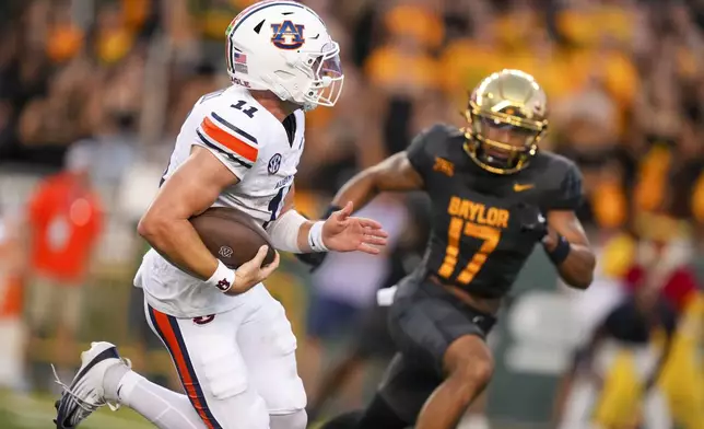 Auburn quarterback Jackson Arnold, left, runs for a touchdown as Baylor linebacker Keaton Thomas tries to stop him during the first half of an NCAA college football game Friday, Aug. 29, 2025, in Waco, Texas. (AP Photo/Julio Cortez)