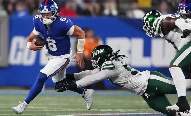 New York Giants quarterback Jaxson Dart (6) is sacked by New York Jets defensive end Kingsley Jonathan (57) during the second quarter of an NFL football game, Saturday, Aug. 16, 2025, in East Rutherford, N.J. (AP Photo/Yuki Iwamura)