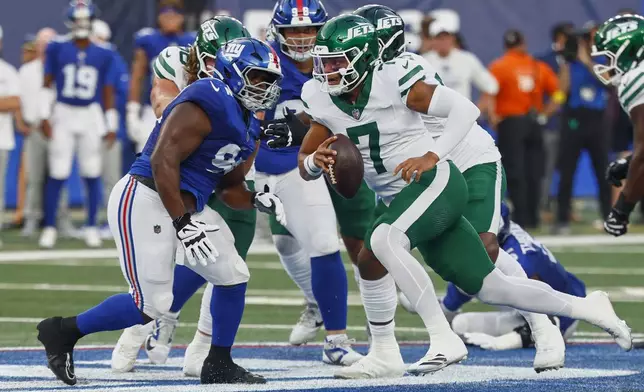 New York Jets quarterback Justin Fields (7) rolls out of the pocket against the New York Giants during the second quarter of an NFL football game, Saturday, Aug. 16, 2025, in East Rutherford, N.J. (AP Photo/Noah K. Murray)