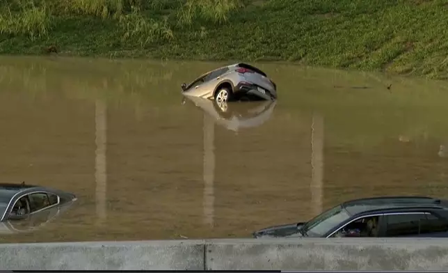 A vehicle is submerged in a flooded road in Chattanooga, Tenn., Tuesday, Aug. 12, 2025. (WTVC via AP)