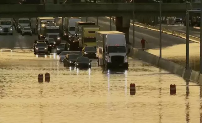 Traffic moves through a flooded road in Chattanooga, Tenn., Tuesday, Aug. 12, 2025. (WTVC via AP)