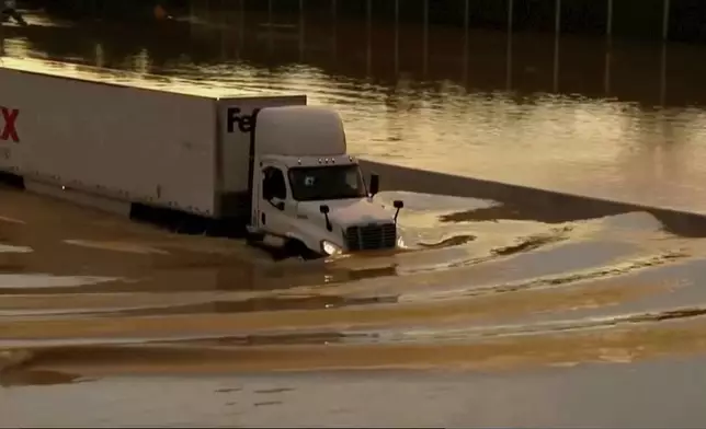 A truck drives through flooded road in Chattanooga, Tenn., Tuesday, Aug. 12, 2025. (WTVC via AP)