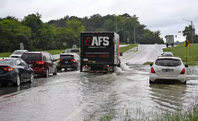 Traffic moves slowly through floodwaters on Bonny Oaks Drive, in Chattanooga, Tenn., on Aug. 12, 2025. (Mason Edwards/Chattanooga Times Free Press via AP)