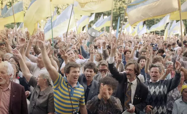 FILE - People wave Ukrainian national flags as they gather outside the parliament building during a pro-independence rally, in Kyiv, Sept. 4, 1991. (AP Photo/Dusan Vranic, File)