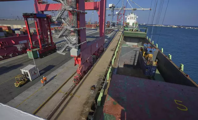 Containers loaded with humanitarian aid for the people of Gaza, including flour, pasta, baby food and canned goods, is being loaded aboard a Panamanian-flagged ship at Cyprus' main port in Limassol, on Monday, Aug. 18, 2025. (AP Photo/Petros Karadjias)