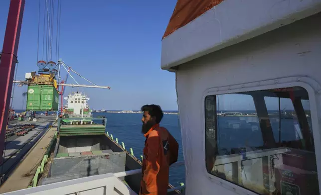 Jalal Uddin, electrical and technology officer aboard a Panamanian-flagged ship watches as containers filled with humanitarian aid for the people of Gaza are being loaded aboard the vessel at Cyprus' main port in Limassol, on Monday, Aug. 18, 2025. (AP Photo/Petros Karadjias)
