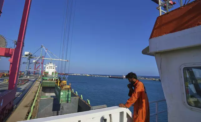 Jalal Uddin, electrical and technology officer aboard a Panamanian-flagged ship watches as containers filled with humanitarian aid for the people of Gaza are being loaded aboard the vessel at Cyprus' main port in Limassol, on Monday, Aug. 18, 2025. (AP Photo/Petros Karadjias)
