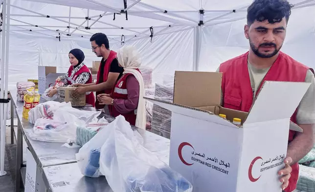 Egyptian Red Crecent members prepare humanitarian aid at their warehouse in the logistical center supporting Gaza, at Sheikh Zuweid, Egypt, Monday, Aug. 18, 2025. (AP Photo/Mayar Mokhtar)