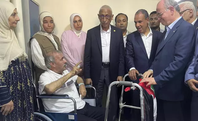 Palestinian Prime Minister Mohammed Mustafa, right, and Egyptian Foreign Minister Badr Abdelatty, second right, visit Palestinian Mohammed Abu Dakkah, from Gaza Strip, who receives medical care at Arish hospital, in Arish, Egypt, Monday, Aug. 18, 2025. (AP Photo/Mohamed Arafat)
