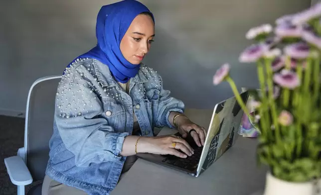 Hoda Abrahim, founder and CEO of Love, Inshallah, a matchmaker featured on the series "Muslim Matchmaker," on Hulu, works on her computer at her home on Monday, Aug. 11, 2025, in Conroe, Texas. (AP Photo/Ashley Landis)