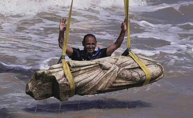 A diver celebrates after one of the ancient relics was lifted out of the water in the Abu Qir Bay in the Mediterranean Sea city of Alexandria, Egypt, Thursday, Aug. 21, 2025. (AP Photo/Amr Nabil)