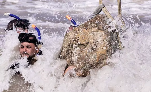 Divers prepare to lift, an unknown statue showing Sphinx, outof the water in Abu Qir Bay at the Mediterranean city of Alexandria, Egypt, Thursday, Aug. 21, 2025. (AP Photo/Amr Nabil)
