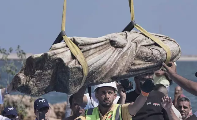 Antiquities workers prepare to place one of the ancient artifacts, unknown priest, after it is lifted out of the water in Abu Qir Bay at the Mediterranean city of Alexandria, Egypt, Thursday, Aug. 21, 2025. (AP Photo/Amr Nabil)