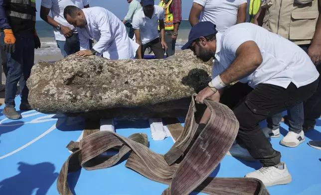 Archeologists untie an ancient artifact, unknown headless statue, as it is lifted out of the water in Abu Qir Bay at the Mediterranean city of Alexandria, Egypt, Thursday, Aug. 21, 2025. (AP Photo/Amr Nabil)