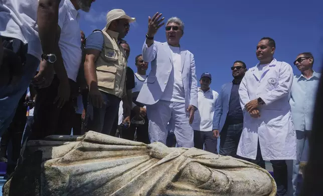 Egyptian Minister of Tourism and Antiquities Sherif Fathy, center, speaks in front of an ancient artifact, unknown priest, recently lifted out of the water in Abu Qir Bay at the Mediterranean city of Alexandria, Egypt, Thursday, Aug. 21, 2025. (AP Photo/Amr Nabil)