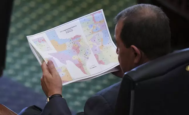 Texas state Sen. Pete Flores, R-Pleasanton, looks over a redrawn U.S. congressional map during debate over a bill in the Senate Chamber at the Texas Capitol in Austin, Texas, Friday, Aug. 22, 2025. (AP Photo/Eric Gay)