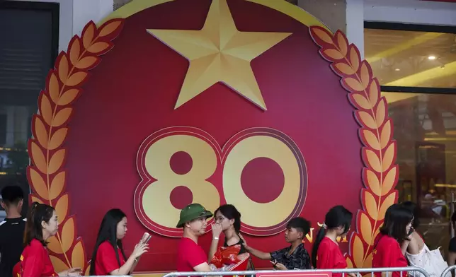Pedestrian walks infront a billboard as the nation celebrating Vietnam's 80th National Day in Hanoi, Friday, Aug. 29, 2025. (AP Photo/Vincent Thian)