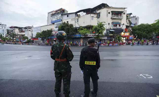 Vietnamese Army and security personal stand guard before a military parade rehearsal for the Vietnam's 80th National Day celebration in old town of Hanoi, Vietnam, Saturday, Aug. 30, 2025. (AP Photo/Vincent Thian)