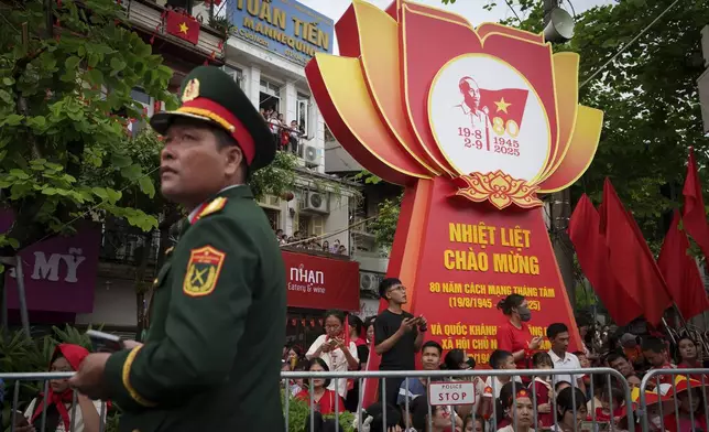 People wait for the final day of a military parade rehearsal for the 80th National Day celebration in Hanoi, Vietnam, Saturday, Aug. 30, 2025. (AP Photo/Vincent Thian)