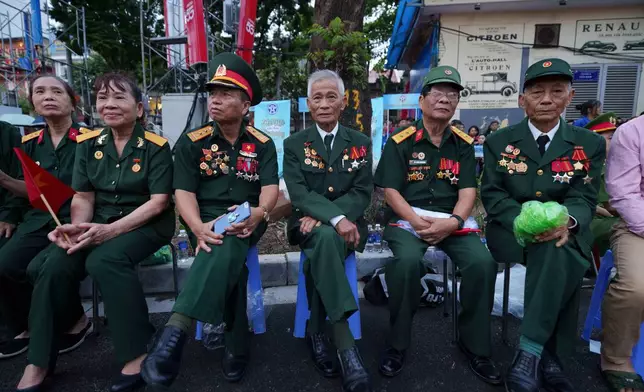 Vietnamese retired veterans wait for military parade rehearsal for the Vietnam's 80th National Day celebration in old town of Hanoi, Vietnam, Saturday, Aug. 30, 2025. (AP Photo/Vincent Thian)