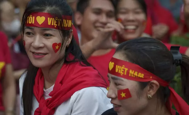 People wait for a military parade rehearsal for the Vietnam's 80th National Day celebration in Hanoi, Vietnam, Saturday, Aug. 30, 2025. (AP Photo/Vincent Thian)