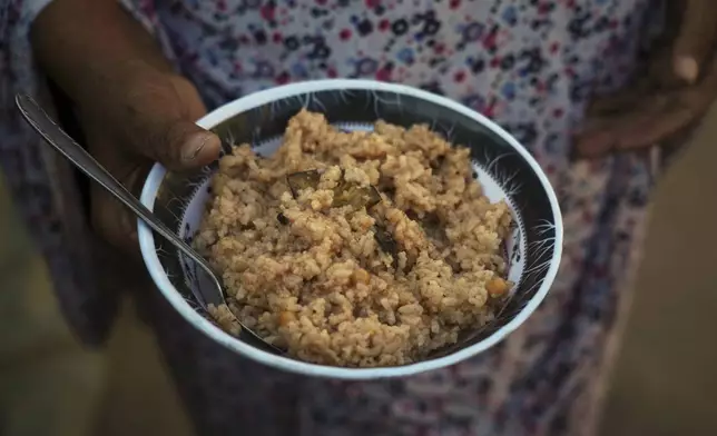 Palestinian woman Souad Hussein, 68, displaced from Al-Maghazi camp, holds a plate of rice, her only food for the day, amid severe food shortages in the Gaza Strip, in Deir al-Balah, Monday, Aug. 4, 2025. (AP Photo/Abdel Kareem Hana)