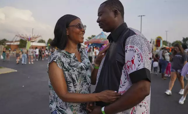 Clarisse Mutombo, left, poses for a portrait with her husband and St. Jude Catholic Church parish council member, Martin Mutombo, both immigrants from Congo, at the St. Jude Catholic Church's Sweet Corn Festival on Saturday, Aug. 9, 2025, in Cedar Rapids, Iowa. (AP Photo/Jessie Wardarski)
