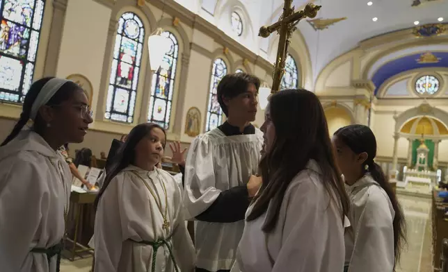 Altar boys and girls talk before service at Immaculate Conception Catholic Church on Sunday, Aug. 10, 2025, in Cedar Rapids, Iowa. (AP Photo/Jessie Wardarski)