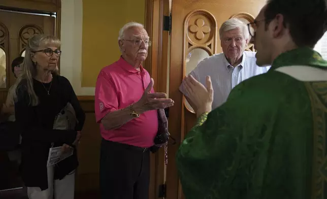 Bob Kazimour, second from left, talks with the Rev. Aaron Junge after Mass at St. Wenceslaus Catholic Church on Saturday, Aug. 9, 2025, in Cedar Rapids, Iowa. (AP Photo/Jessie Wardarski)