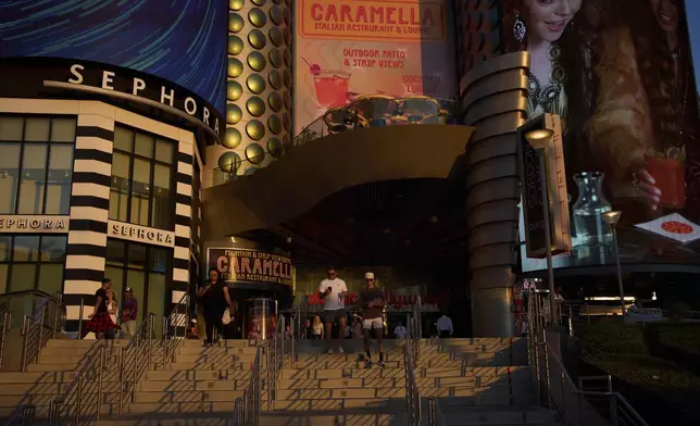 People walk along the Las Vegas Strip, Friday, Aug. 8, 2025, in Las Vegas. (AP Photo/John Locher)