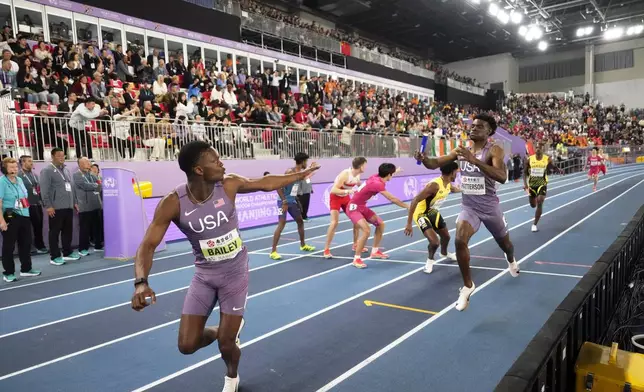 FILE - Jacory Patterson of the U.S. hands the baton to teammate Christopher Bailey on their way to win the gold medal in the men's 4X400 meters relay at the World Athletics Indoor Championships in Nanjing, China, Sunday, March 23, 2025. (AP Photo/Dar Yasin, File)
