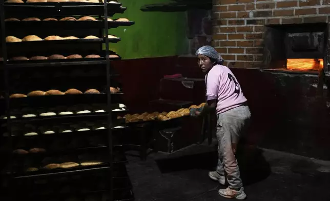 Reina Castillo prepares "pan de batalla," or battle bread, made with government subsidized flour, at a bakery in El Alto, Bolivia, Friday, Aug. 8, 2025. (AP Photo/Juan Karita)
