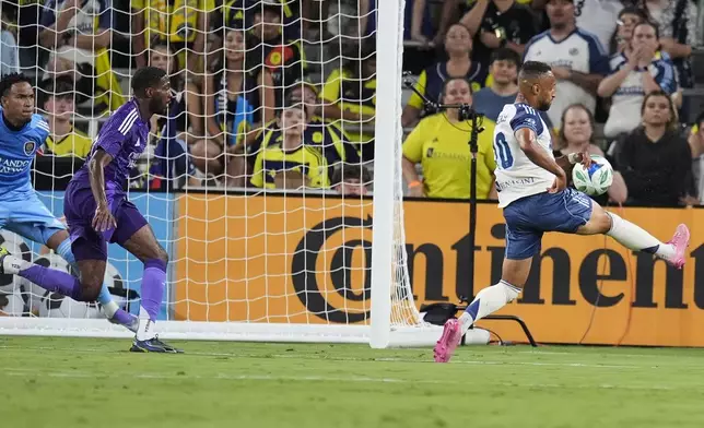 Nashville SC midfielder Hany Mukhtar, right, scores a goal against Orlando City during the first half of an MLS soccer match Saturday, Aug. 23, 2025, in Nashville, Tenn. (AP Photo/George Walker IV)