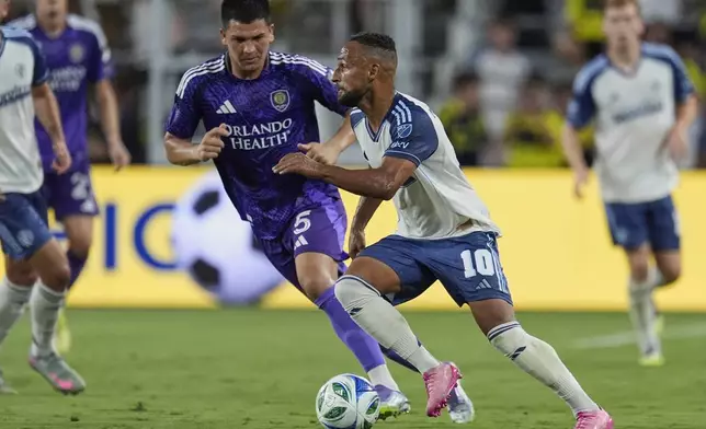 Nashville SC midfielder Hany Mukhtar (10) kicks the ball past Orlando City midfielder César Araújo (5) during the first half of an MLS soccer match Saturday, Aug. 23, 2025, in Nashville, Tenn. (AP Photo/George Walker IV)