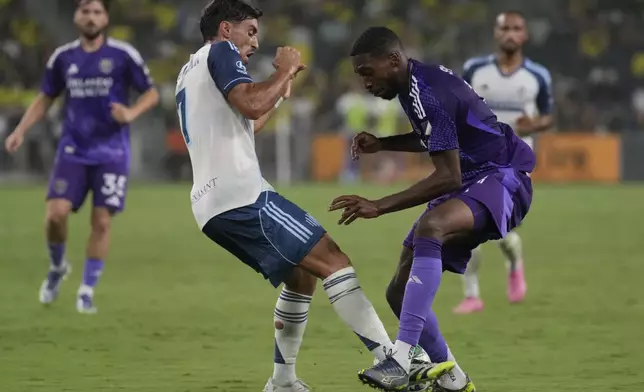 Nashville SC midfielder Gastón Brugman, left, and Orlando City forward Tyrese Spicer, right, vie for the ball during the first half of an MLS soccer match Saturday, Aug. 23, 2025, in Nashville, Tenn. (AP Photo/George Walker IV)