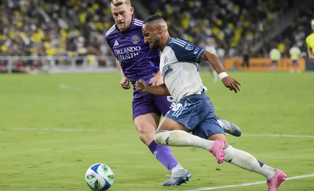 Nashville SC midfielder Hany Mukhtar, right, moves the ball past Orlando City defender Robin Jansson, left, during the second half of an MLS soccer match Saturday, Aug. 23, 2025, in Nashville, Tenn. (AP Photo/George Walker IV)