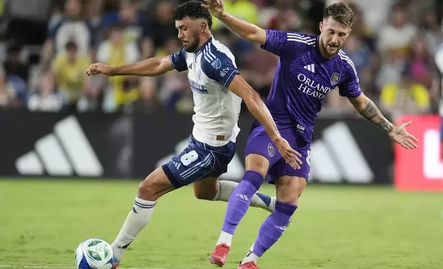 Nashville SC midfielder Patrick Yazbek (8) kicks the ball past Orlando City forward Marco Pašalić, right, during the second half of an MLS soccer match Saturday, Aug. 23, 2025, in Nashville, Tenn. (AP Photo/George Walker IV)