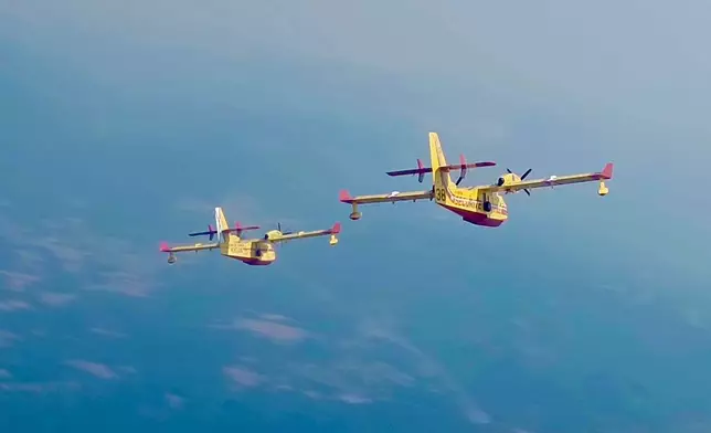 This recent photo provided by the Securite Civile shows two French Canadair water bombers flying over Spain. (Securite Civile via AP)