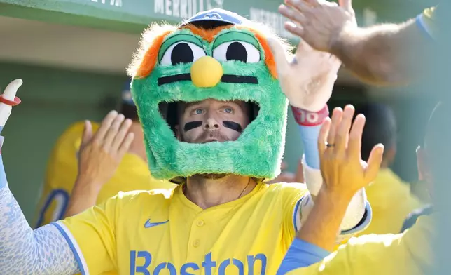 Boston Red Sox's Trevor Story wears a Wally the Green Monster mask after hitting a two-run home run in the third inning of a baseball game against the Houston Astros, Saturday, Aug. 2, 2025, in Boston. (AP Photo/Greg M. Cooper)