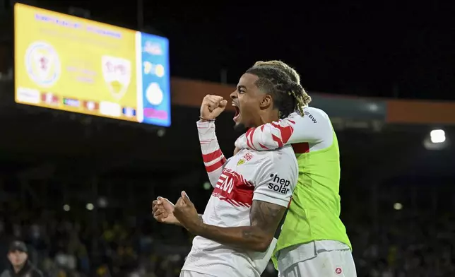 Stuttgart's Lorenz Assignon, left, celebrates after converting his kick during a penalty shootout against Eintracht Braunschweig during a DFB Pokal, German Cup, soccer match, Tuesday, Aug. 26, 2205, in Brunswick, Germany. (Swen Pförtner/dpa via AP)